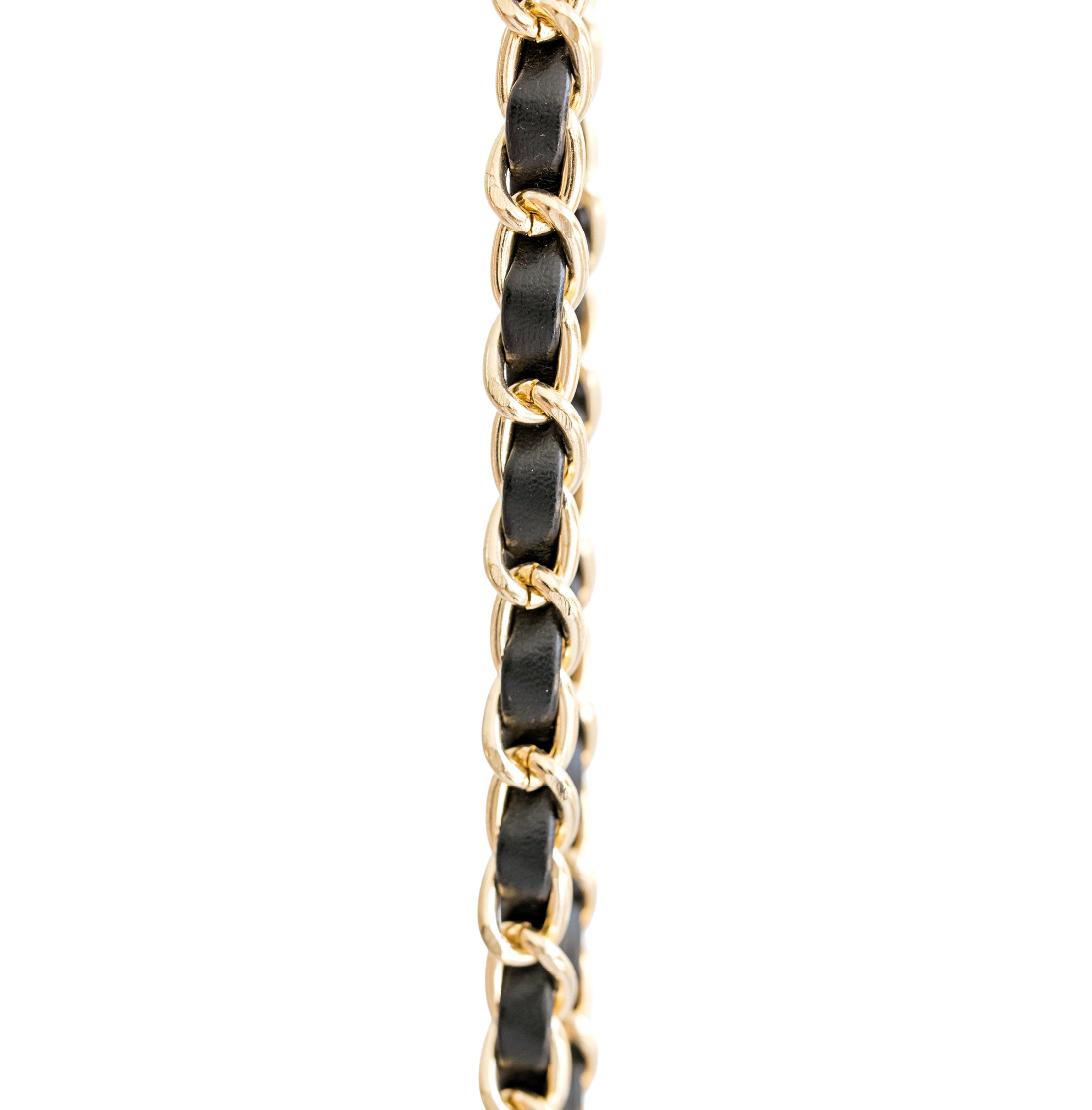 A close-up of a gold-tone chain link with a black inlay, shown vertically against a plain white background.