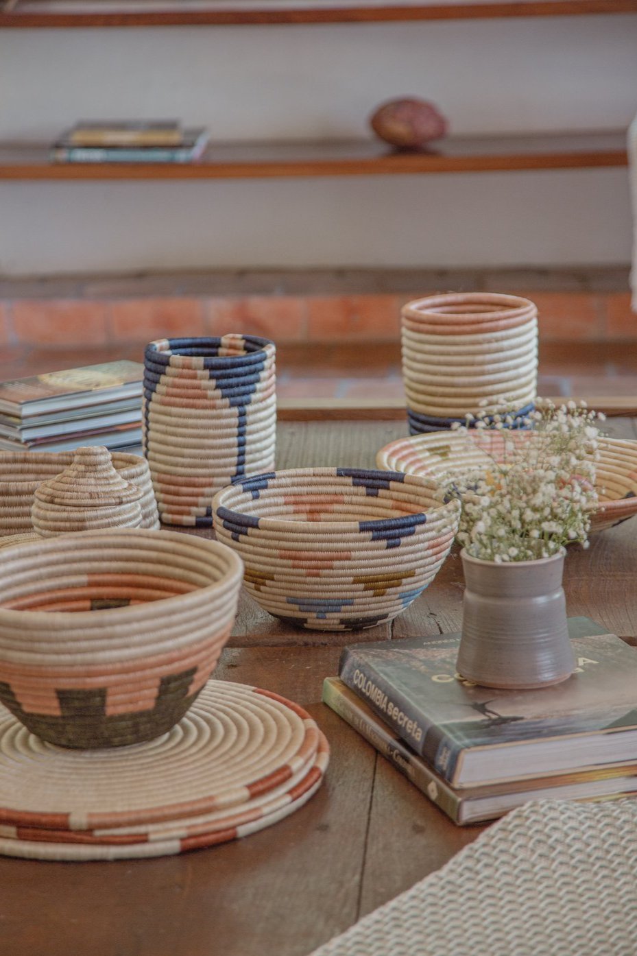 A vibrant fruit bowl featuring a blend of navy blue, cielo blue, salmon pink, olive green, and natural colors. Made from 100% natural fique, this handcrafted piece from Guacamayas, Colombia, adds a lively Caribbean touch to any table or shelf. Dimensions: 15 x 25 cm.