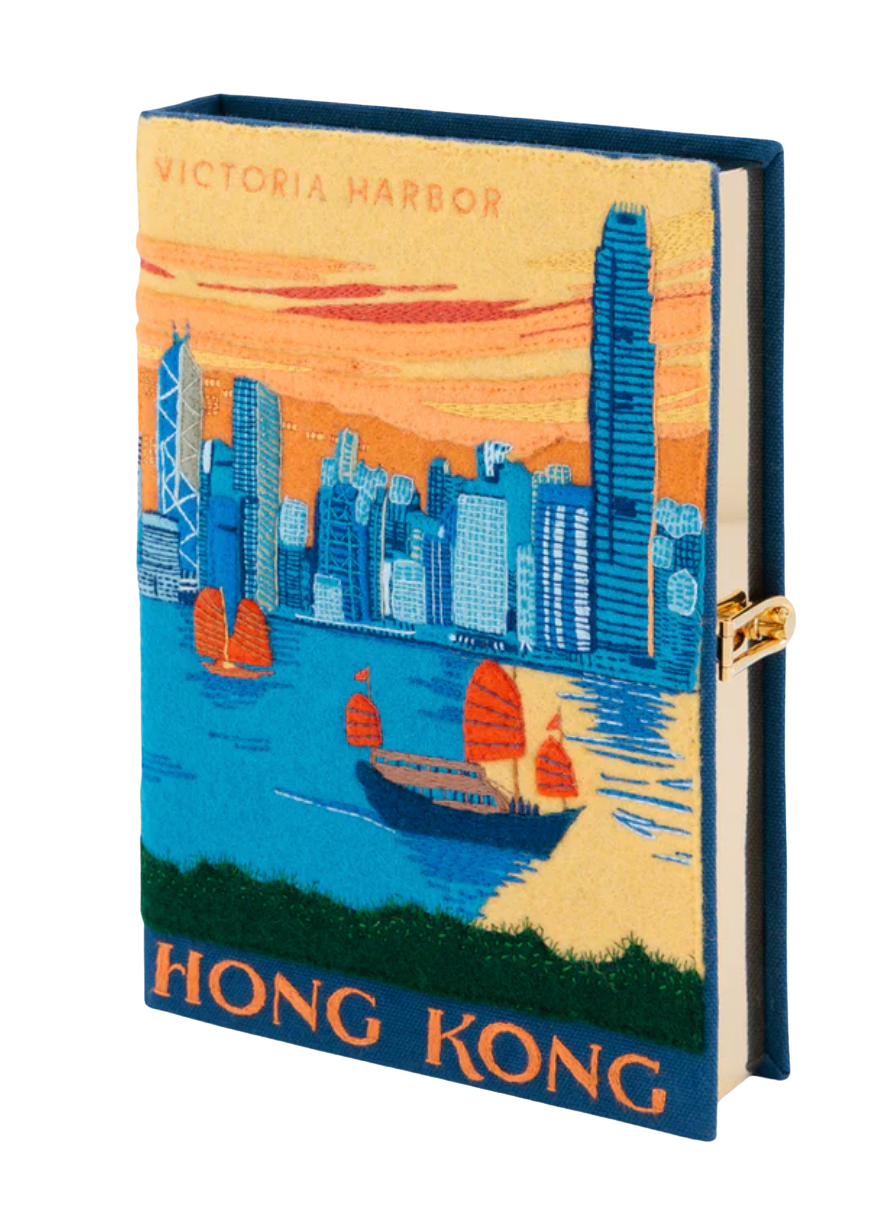 A small hardcover notebook or journal featuring a colorful illustrated cover of the Hong Kong skyline with Victoria Harbor, boats, and skyscrapers. The cover reads 'VICTORIA HARBOR' at the top and 'HONG KONG' at the bottom.