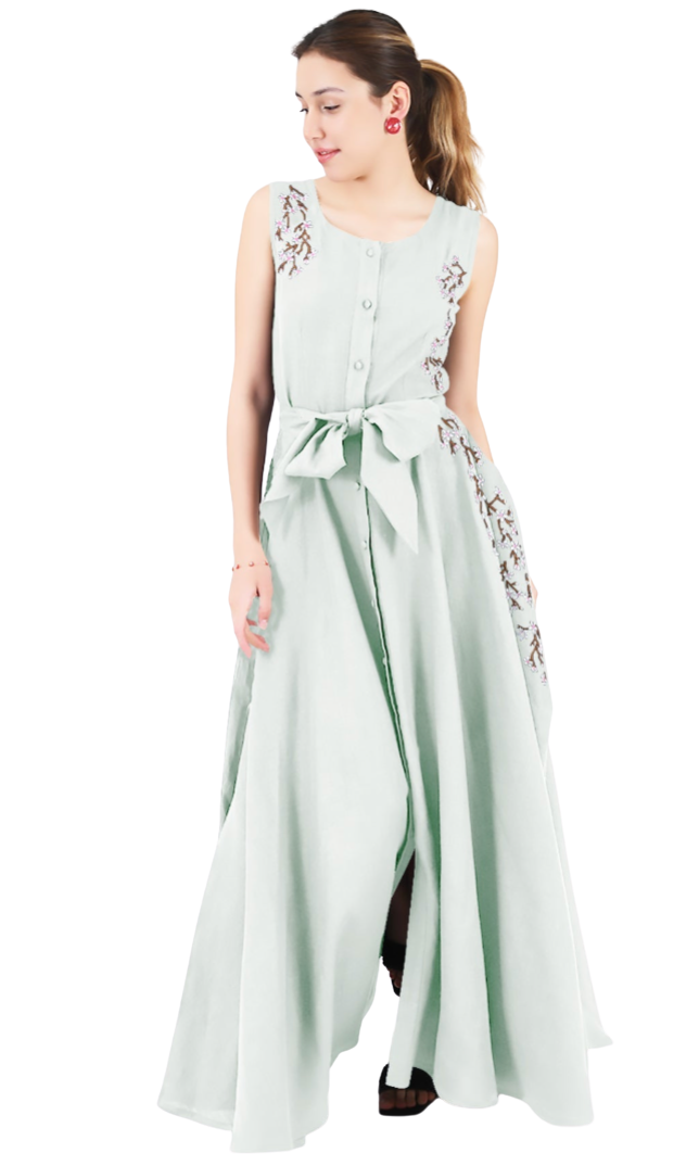 Woman wearing a light green sleeveless dress with floral embroidery on a white background