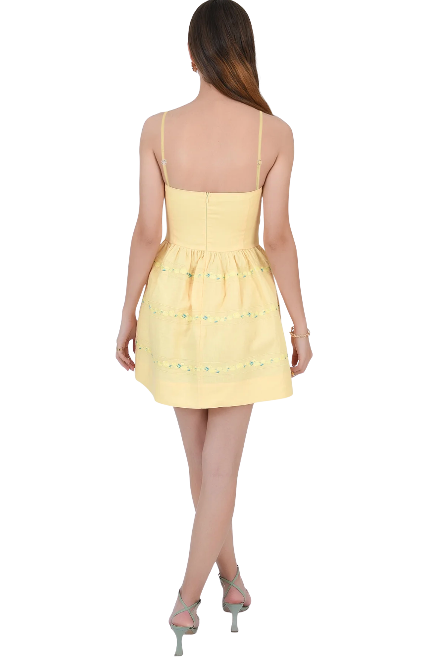 Yellow dress with lace details on a white background