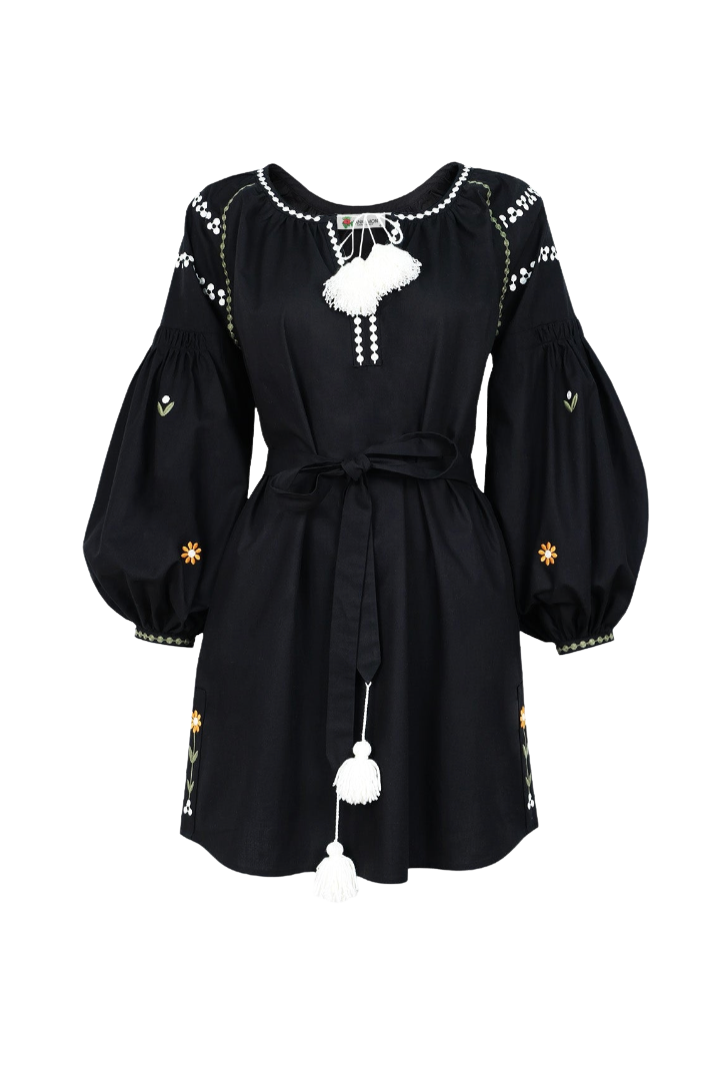 A black bohemian-style mini dress with voluminous balloon sleeves, a tie waist, and white embroidered details, including a central tassel ornament.